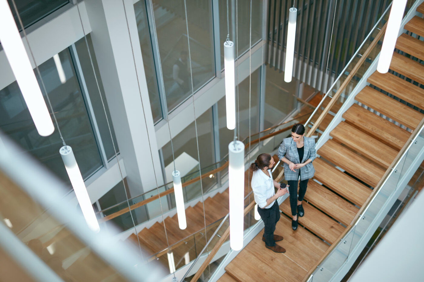 Business People Working In Modern Office. Man And Woman Walking On Stairs In Contemporary Business Center Interior. High Resolution