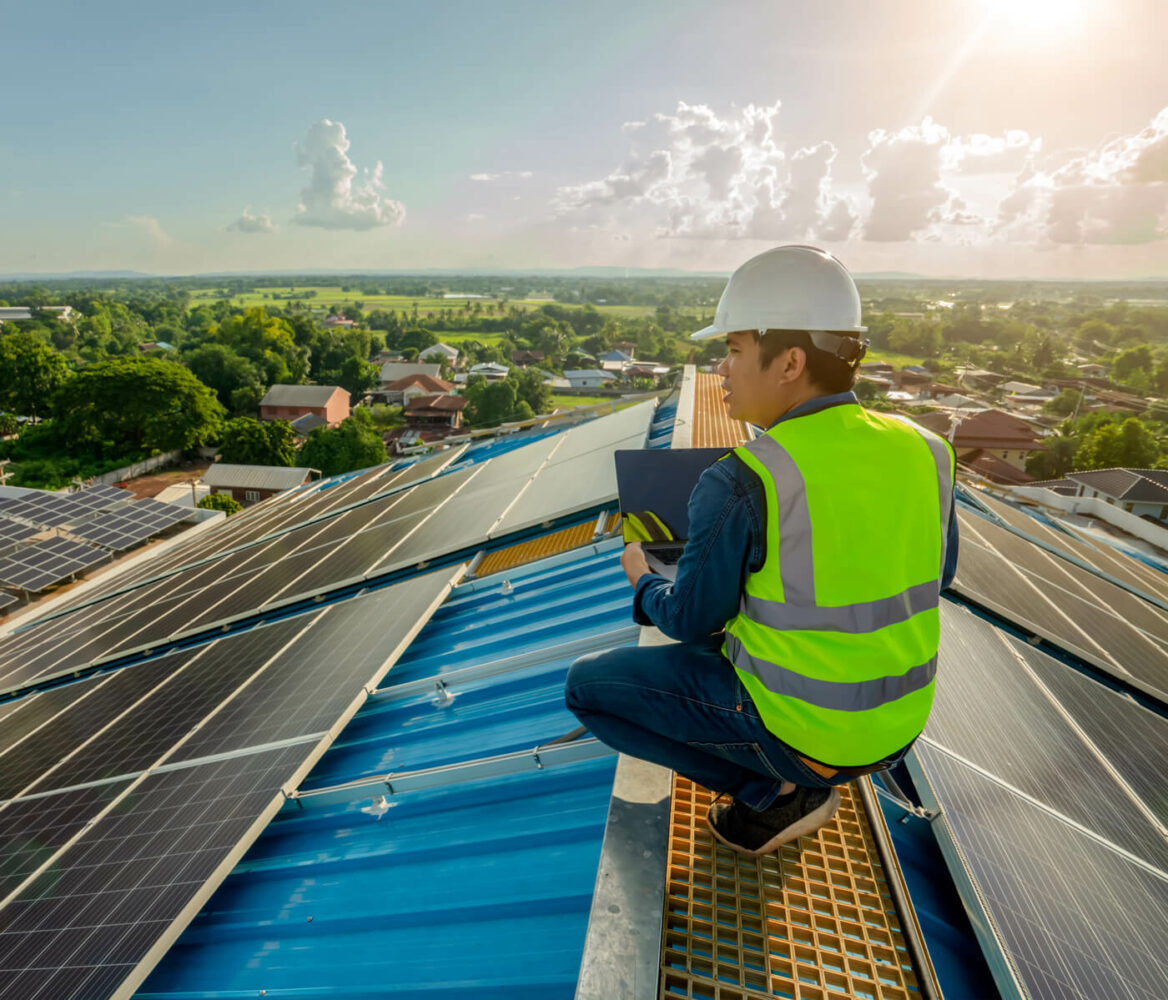Worker on a roof with solar panels